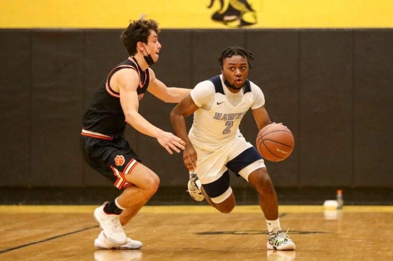   Bryce Tillery (2) dari Hillcrest menggerakkan bola melepasi Wheaton-Warrenville South.