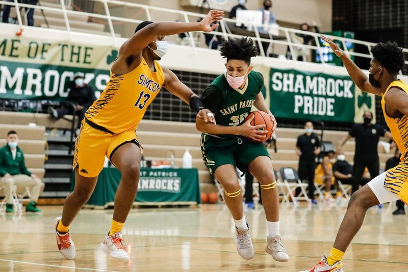 Timaris Brown (30) de St. Patrick contrôle le ballon alors que Phillip Holmes jr. de Simeon. (13) défend.