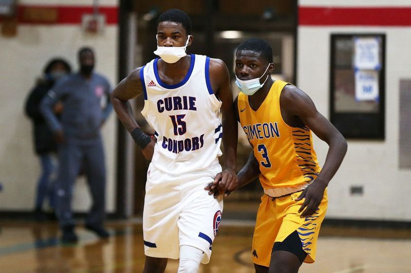 Ahamad Bynum de Simeon (3) et Phillip Berryhill (15) de Curie se préparent pour un jeu d