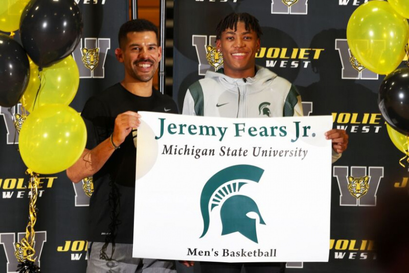   Jeremy Fears Jr., abgebildet mit seinem Trainer Jeremy Kreiger, akzeptiert ein Banner als Anerkennung für die Unterzeichnung einer nationalen Absichtserklärung, an der Michigan State University Basketball zu spielen.