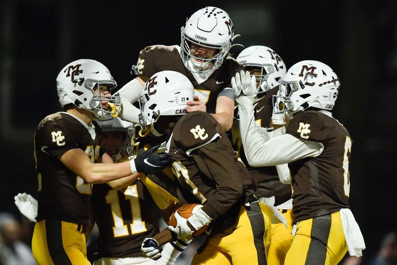 Dennis Furlong (11), Blainey Dowling (7) y Darrion Gilliam (17) de Mount Carmel celebran con sus compañeros de equipo durante el partido contra Batavia.
