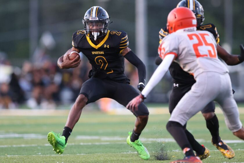   Kyle Thomas (2) z Marian Catholic lekko podskakuje obrońcy Lwa, gdy ten tnie.