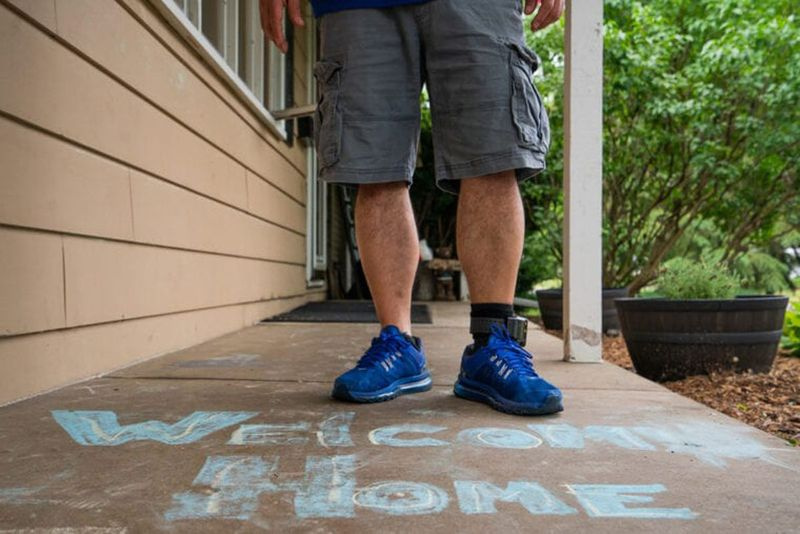 Cesar Elizarraraz staat met een welkomstbericht op de veranda van zijn huis in Crystal Lake. Hoewel hij herenigd is met zijn familie, is zijn zaak nog lang niet voorbij.
