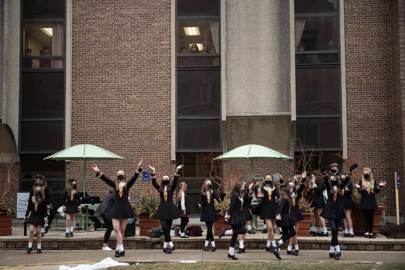 Trinity Irish Dancers vystupují před švédskou nemocnicí Covenant na Den svatého Patrika, aby vyjádřili uznání zdravotnickým pracovníkům.