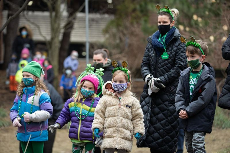Děti zdravotnických pracovníků a zaměstnanců sledují vystoupení Trinity Irish Dancers před švédskou nemocnicí Covenant na Den svatého Patrika.