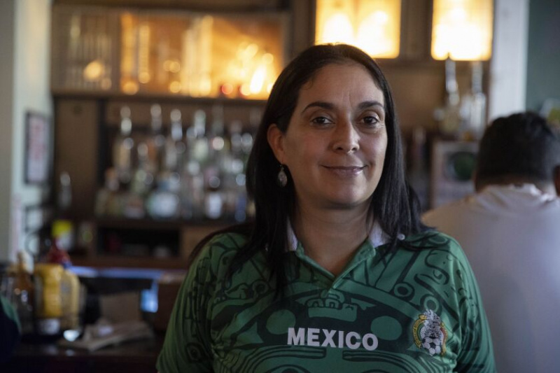   Adriana Kenning, 44, nosí mexický dres, který si koupila ve svém rodném městě Tijuana v Mexiku v Simone's, 960 W. 18th St. v Plzni, kde se shromáždili příznivci Mexika a Polska, aby sledovali, jak oba týmy jdou proti sobě. na mistrovství světa ve fotbale. 