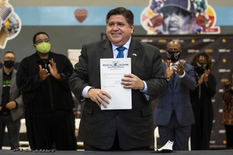 Gouverneur J.B. Pritzker tekent maandag tijdens een persconferentie aan de West Side een uitvoerend bevel over de bestrijding van wapengeweld.