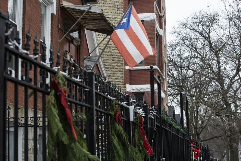 Eine puertorikanische Flagge und Weihnachtsdekorationen hängen am Donnerstagnachmittag, 17. Dezember 2020, vor einem Haus im Block 2700 der West Potomac Avenue im Humboldt Park auf der West Side. | Ashlee Rezin Garcia/Sun-Times