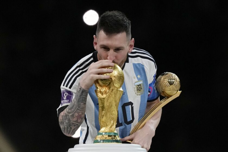   Argentinec Lionel Messi líbá trofej pro mistrovství světa poté, co jeho tým ve finále porazil Francii. Argentina vyhrála 4:2 v penaltovém rozstřelu poté, co zápas skončil nerozhodně 3:3.