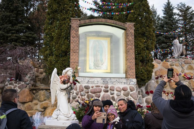 Ljudje fotografirajo po procesiji v svetišču Marije Guadalupe v Des Plainesu decembra 2017.