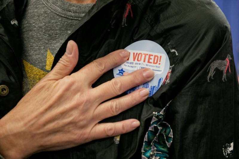   Linda McCully lipește un autocolant pe care scrie „Am votat!” pe jachetă după ce și-a votat devreme la Supersite-ul pentru vot anticipat al Consiliului Electoral din Chicago, la 191 N. Clark St. in the Loop, vineri, 7 octombrie 2022. | Pat Nabong/Sun-Times