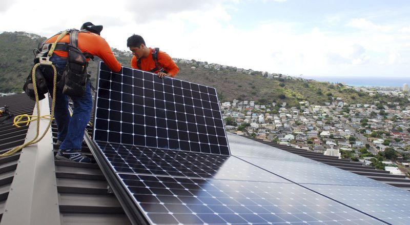 Paigaldajad panevad päikesepaneelid Honolulus katusele. Kliendid peaksid kontrollima elektriarveid, et hinnata igakuist energiatarbimist, kui nad otsustavad, millise suurusega süsteemi osta, ja arvutama föderaal- või osariigi stiimulid.