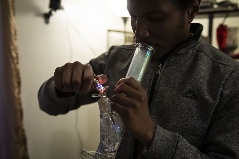 David Richardson, 29, sitzt in seinem Wohnzimmer in Rogers Park und raucht Marihuana, das er am Neujahrstag bei der Dispensary 33, 5001 N. Clark St. gekauft hat.
