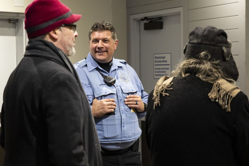 Pegawai Polis Joliet Jeremy Eaton berbual dengan pelanggan di Rise Joliet, dispensari ganja di pinggir bandar barat daya Joliet, pada hari pertama ganja rekreasi yang sah di Illinois, Rabu, 1 Januari 2020.
