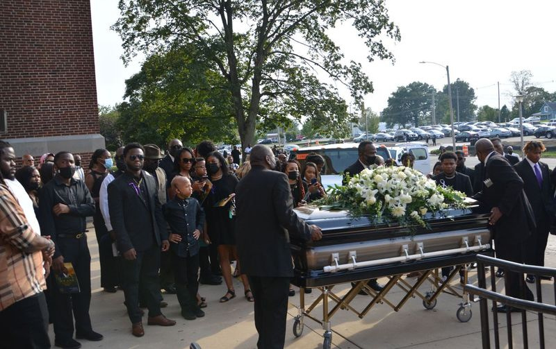 Os enlutados se reúnem do lado de fora da Danville High School no sábado, enquanto o caixão de Jelani Day é levado aos carregadores que aguardam em Danville.