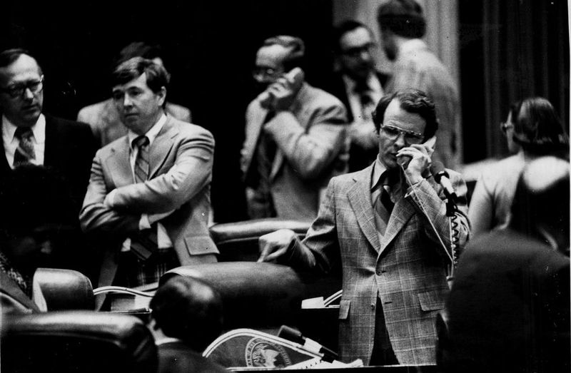 Wakil Negeri Mike Madigan, kanan, bercakap melalui telefon semasa sesi Dewan pada tahun 1979.