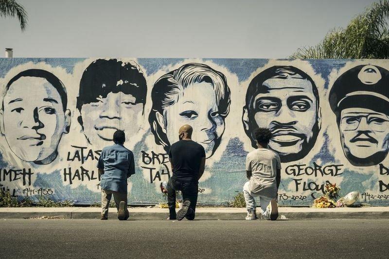 Obba Babatunde som skildrer Daniel Harrison Sr., (fra venstre), Shemar Moore som sønnen Hondo, og Deshae Frost som Darryl, kneler foran et veggmaleri i en scene fra S.W.A.T.