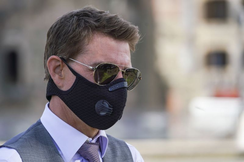 Tom Cruise bærer en ansigtsmaske for at forhindre spredning af COVID-19, da han hilser på fans under en pause fra optagelserne af Mission Impossible 7 tidligere på året i Rom, Italien.