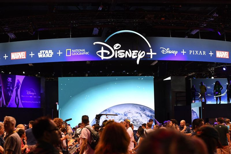 Uczestnicy odwiedzają stoisko usługi przesyłania strumieniowego Disney+ na targach D23 Expo w sierpniu w Anaheim Convention Center w Anaheim w Kalifornii. Disney Plus zostanie uruchomiony 12 listopada.