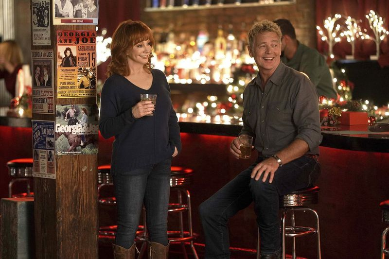 Reba McEntire e John Schneider são mostrados em uma cena do especial de Natal Reba McEntire
