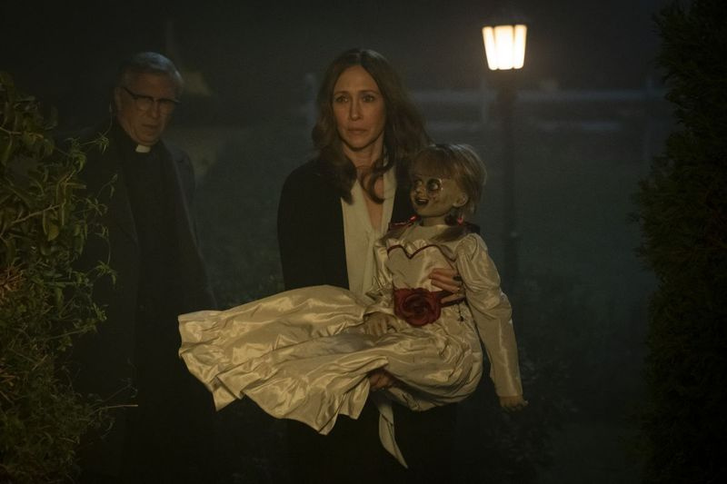 STEVE COULTER como el padre Gordon, VERA FARMIGA como Lorraine Warren y la muñeca Annabelle en la película de terror de New Line Cinema ANNABELLE COMES HOME, un estreno de Warner Bros. Pictures.