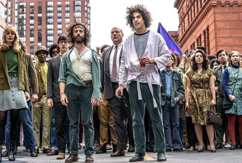 ケイトリン・フィッツジェラルド（前景、左から）、ジェレミー・ストロング、サーシャ・バロン・コーエンがシカゴ7裁判のシーンで示されています。