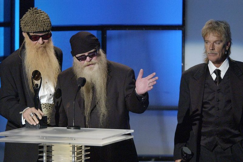 Grupa ZZ Top, tostarp Billijs Gibons (no kreisās) Dusty Hill un Frenks Bērds, pieņem savu iestādīšanas balvu 19. ikgadējā Rokenrola slavas zāles uzņemšanas ceremonijā 2004. gada 15. martā Ņujorkā.