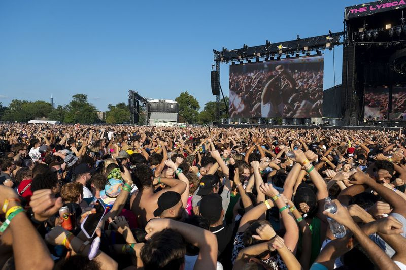 Fanúšikovia si prekrížia ruky a zdvihnú ich do vzduchu počas vzdávania pocty Juice WRLD v nedeľný tretí deň Summer Smash Festivalu v Douglass Parku.