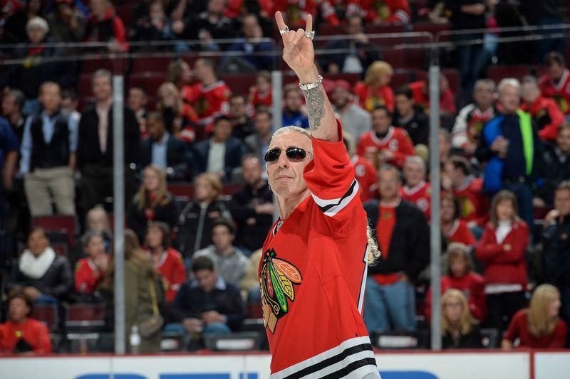 Dee Snider z Twisted Sister sa prihovorí publiku predtým, ako vystrelí puk medzi jednotlivými obdobiami zápasu NHL medzi Calgary Flames a Chicagom Blackhawks v roku 2014 v United Center.