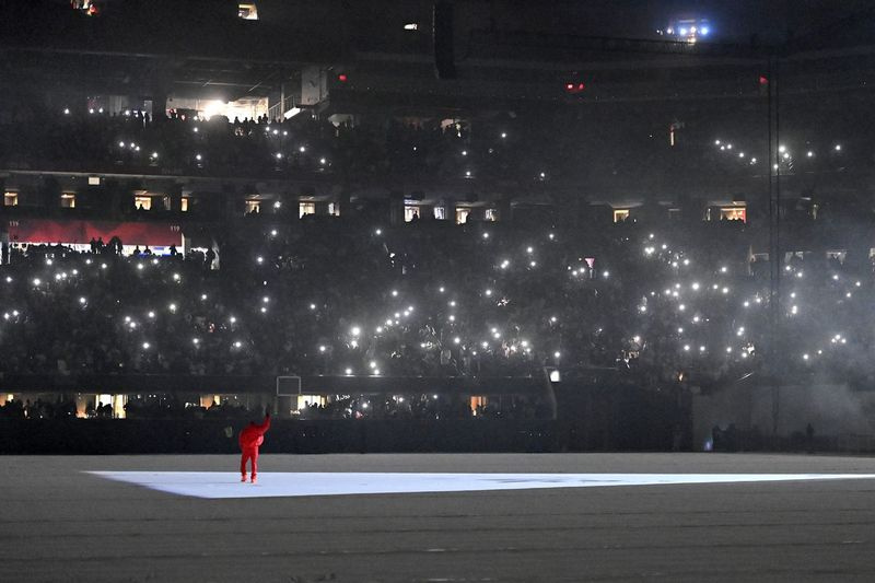 Kanye West máva publiku počas svojho piatkového počúvania Donda na štadióne Mercedes-Benz v Atlante.