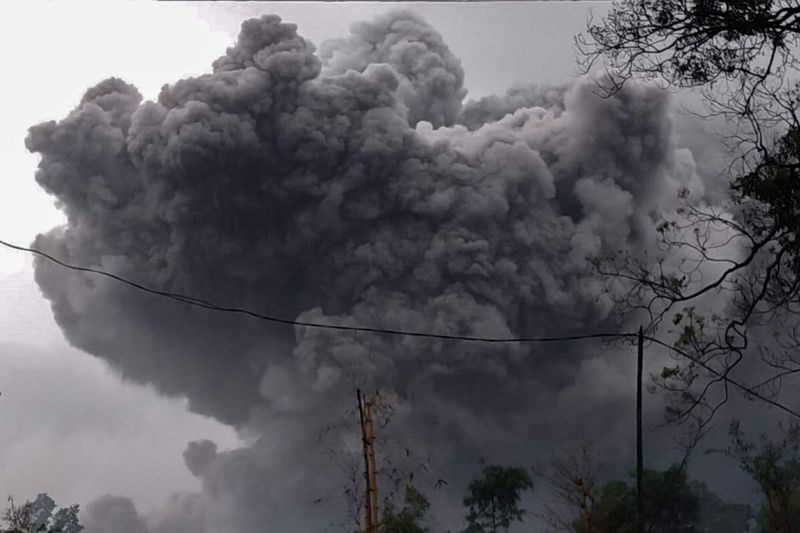 Ta fotografija iz izročka, ki jo je 16. januarja 2021 posnel in objavil Indonezijski nacionalni odbor za obvladovanje nesreč (BNPB), prikazuje goro Semeru, ki bruha pepel med izbruhom v Lumajangu na vzhodni Javi.