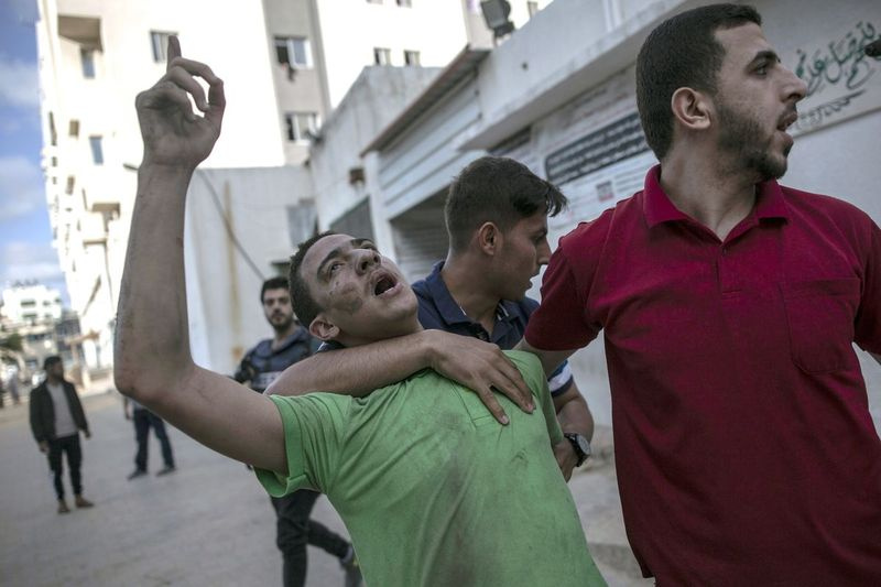 Palestínčan reaguje na smrť svojho otca, ktorého zabil izraelský nálet, ktorý zničil horné poschodia komerčnej budovy a spôsobil škody na neďalekom ministerstve zdravotníctva a klinike primárnej zdravotnej starostlivosti v meste Gaza, pondelok 17. mája 2021. .