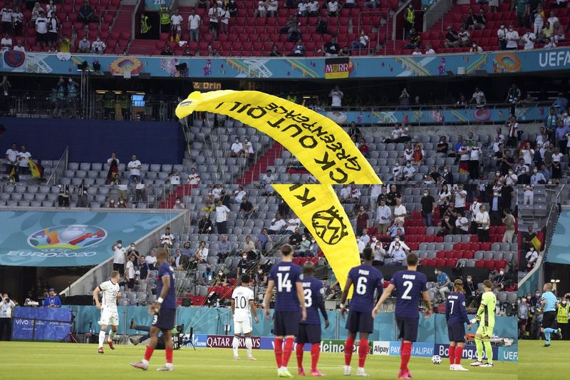 En skärmflygare från Greenpeace landar på planen före EM 2020-matchen i grupp F i fotboll mellan Frankrike och Tyskland på Allianz Arena i München, Tyskland, tisdagen den 15 juni 2021.