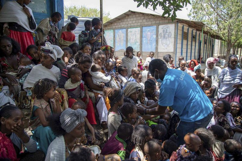 UNICEF-Ernährungsspezialist Joseph Senesie (rechts) untersucht Kinder in Adikeh im Distrikt Wajirat der Region Tigray im Norden Äthiopiens auf Unterernährung.