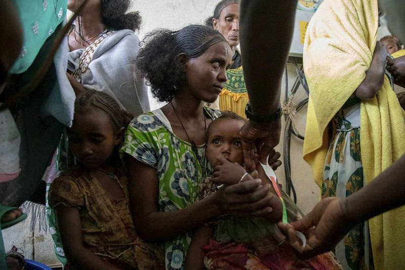 Eine Frau hält ein Kind während einer Untersuchung auf Mangelernährung bei schwangeren und stillenden Frauen durch UNICEF und Partner in Gijet in der Region Tigray im Norden Äthiopiens.