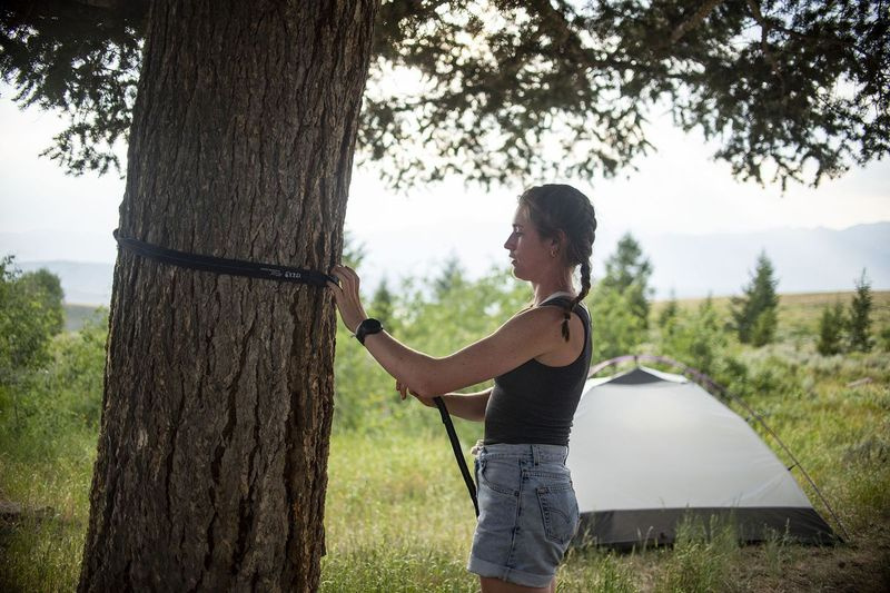 Erica Robertson justerer hengekøyen sin i det vestlige Wyomings Curtis Canyon. Robertson er en av mange mennesker som lever ut av bilene sine fordi de ikke har råd til Jackson Holes dyre boligmarked.