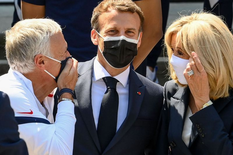 Francouzský trenér Didier Deschamps hovoří s francouzským prezidentem Emmanuelem Macronem a jeho manželkou Brigitte Macronovou před obědem s francouzskými hráči v Clairefontaine-en-Yvelines 10. června 2021 před fotbalovou soutěží UEFA EURO 2020.