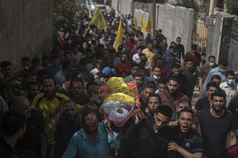 Palestinští smuteční hosté nesou tělo 11letého Hussaina Hamada, který byl zabit výbuchem během probíhajícího konfliktu mezi Izraelem a Hamásem, během jeho pohřbu v Beit Hanoun na severu Pásma Gazy v úterý 11. května 2021.