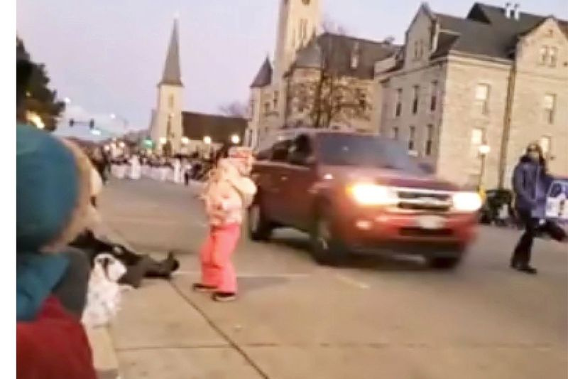 En esta imagen tomada del video, una camioneta pasa a toda velocidad junto a una niña y otras personas que asisten a un desfile de Navidad y continúa conduciendo a través del desfile, hiriendo a varias personas, el domingo 21 de noviembre de 2021 en Waukesha, Wisconsin.