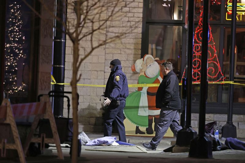 Investigadores de la policía en el centro de Waukesha, Wisconsin, después de que una camioneta se estrellara contra un desfile de manifestantes navideños, matando a varias personas el domingo 21 de noviembre de 2021.