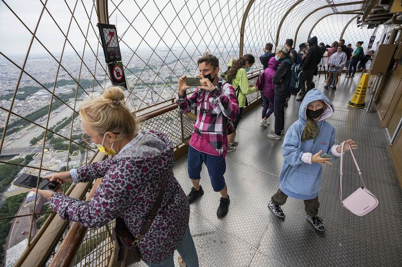 På dette arkivbillede fredag ​​den 16. juli 2021 nyder besøgende udsigten fra toppen af ​​Eiffeltårnet i Paris. Den Europæiske Union forventes at anbefale, at dens medlemslande genindfører restriktioner for turister fra USA på grund af stigende coronavirus-infektionsniveauer i landet, sagde EU-diplomater mandag den 30. august.