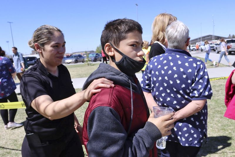 Adela Rodriguez, à gauche, marche avec son fils, Yandel Rodriguez, 12 ans, au lycée où des personnes ont été évacuées après une fusillade au Rigby Middle School voisin plus tôt le jeudi 6 mai 2021, à Rigby, Idaho.