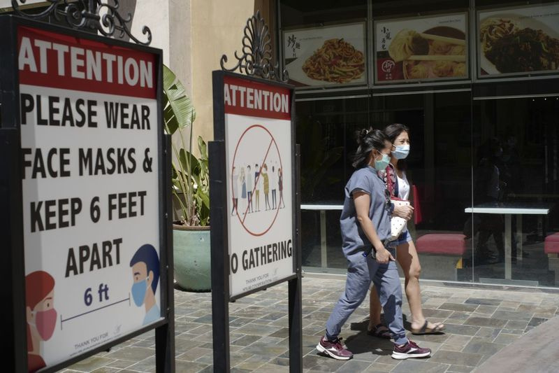 I detta arkivfoto 11 juni 2021 bär kunder ansiktsmasker i en utomhusgalleria med stängd verksamhet mitt i covid-19-pandemin i Los Angeles. Coronavirusfallen har ökat med 500 % i Los Angeles County under den senaste månaden och hälsomyndigheter varnade tisdagen den 13 juli 2021 för att den särskilt smittsamma deltavarianten av sjukdomen fortsätter att spridas snabbt bland Kaliforniens ovaccinerade befolkning.