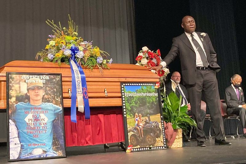 Právník Ben Crump stojí vedle rakve Huntera Brittaina v Beebe High School Auditorium před jeho vzpomínkovou bohoslužbou v Beebe, Ark., v úterý 6. července 2021. Brittain byl zastřelen zástupcem šerifa okresu Lonoke během dopravní zastávky 23. června .