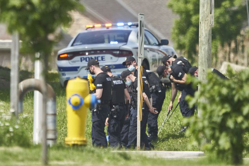 Linia policjantów szuka dowodów na miejscu wypadku samochodowego w Londynie, Ontario w poniedziałek, 7 czerwca 2021 r. Policja twierdzi, że wiele osób zginęło po tym, jak kilku pieszych zostało potrąconych przez samochód w niedzielę wieczorem.