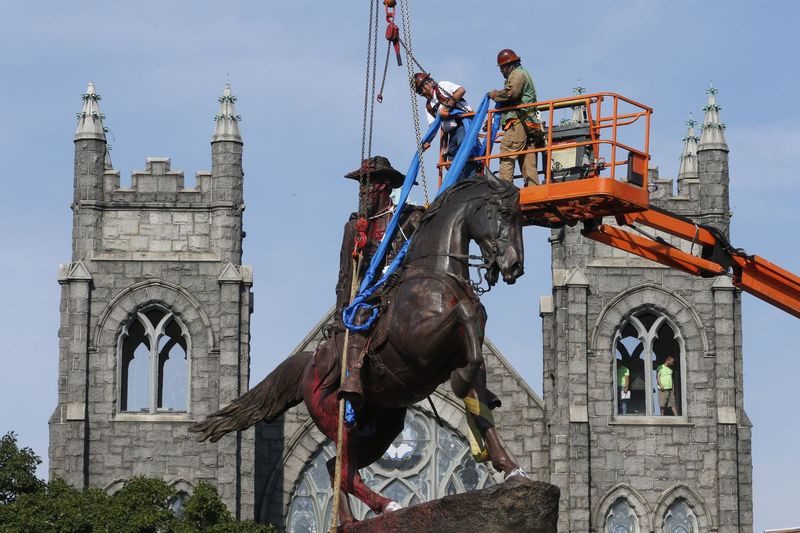 Na této archivní fotografii ze 7. července 2020 posádky připevňují popruhy k soše Generál Konfederace J.E.B. Stuarta na Monument Avenue v Richmondu ve Virginii. V roce 2020 bylo odstraněno nebo přemístěno z veřejných prostranství nejméně 160 symbolů Konfederace.