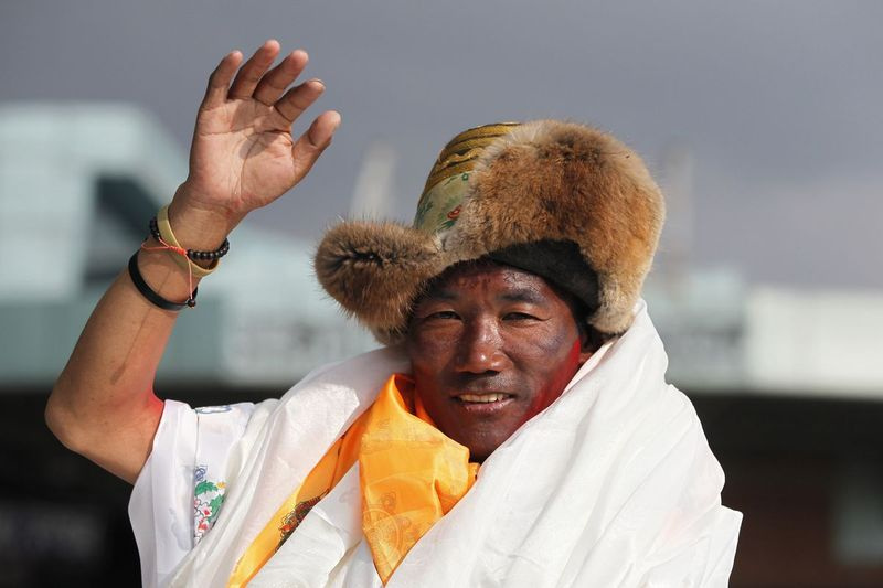 Sellel 20. mail 2018 tehtud fotol lehvitab Nepali veteran šerpade giid Kami Rita, kui ta saabub Nepali Katmandusse.