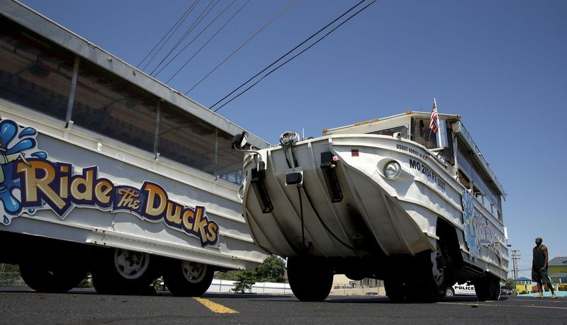 Um homem olha para um barco de patos ocioso no estacionamento da Ride the Ducks sábado, 21 de julho de 2018 em Branson, Missouri | AP Photo / Charlie Riedel)