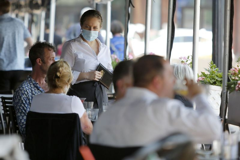 En server förbereder sig för att ta emot en beställning från kunder som sitter utanför på Legal Sea Foods onsdagen den 26 maj 2021 i Boston.