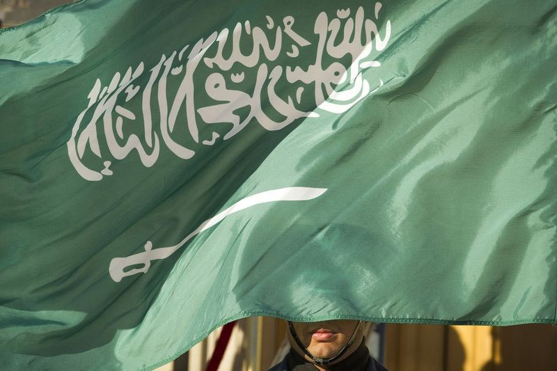 I detta arkivfoto den 22 mars 2018 täcks en hedersvaktmedlem av Saudiarabiens flagga i Washington.